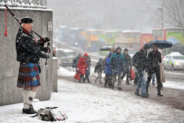 Pictured on Waverley Bridge, Edinburgh, are shoppers battling through the blizzards. 19th December 2010.
