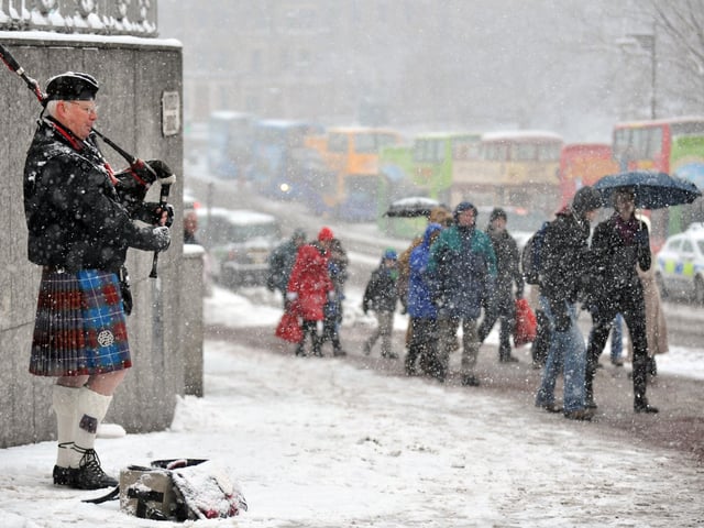Pictured on Waverley Bridge, Edinburgh, are shoppers battling through the blizzards. 19th December 2010.