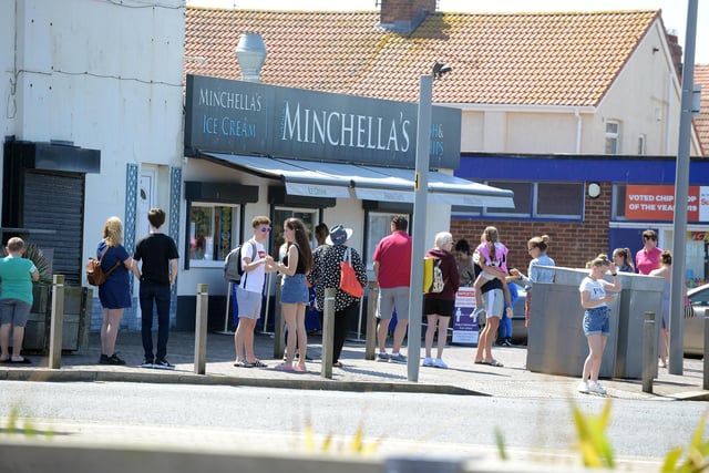 People can be seen following social distancing measures while queuing for fish and chips.