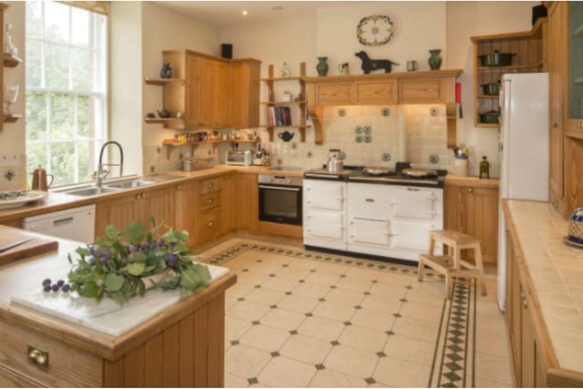 The kitchen is a beautiful space with lots of natural light and attractive wood panelling.