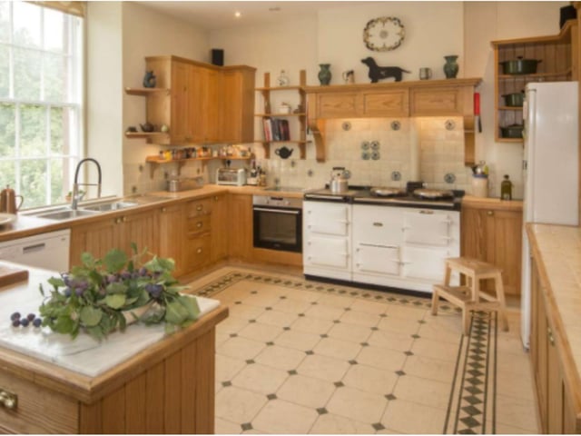 The kitchen is a beautiful space with lots of natural light and attractive wood panelling.