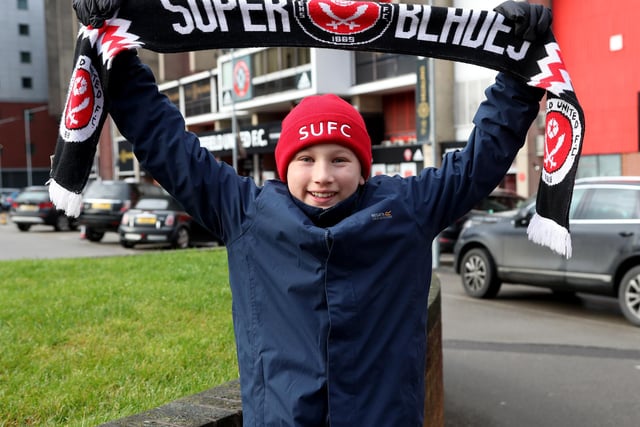 A young United fan holds aloft his scarf before the game with Northampton Town at Bramall Lane on New Year's Eve.