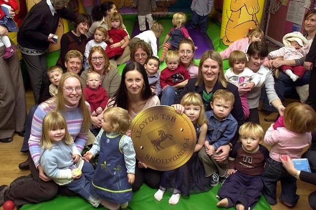 Michelle Fox, centre, receives a gold coin from Jane Brown, right, of Lloyds TSB Bank. The bank gave the Sticky Fingers Toddlers Group at Oughtibridge a grant of £1493.......December 2003