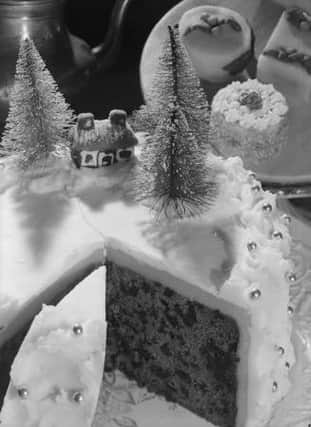 A rich fruit Christmas cake decorated with icing a little house and Christmas trees. 1st September 1948:   (Photo by Chaloner Woods/Getty Images)