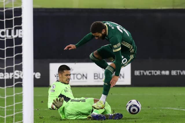 Alphonse Areola of Fulham tackles Jayden Bogle of Sheffield United towards the end of Saturday night's match at Craven Cottage: David Klein/Sportimage