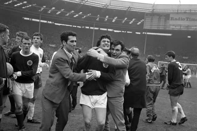 Scotland's Jim Baxter is hugged by fans who invaded the pitch at Wembley following the 3-2 victory over England in 1967.