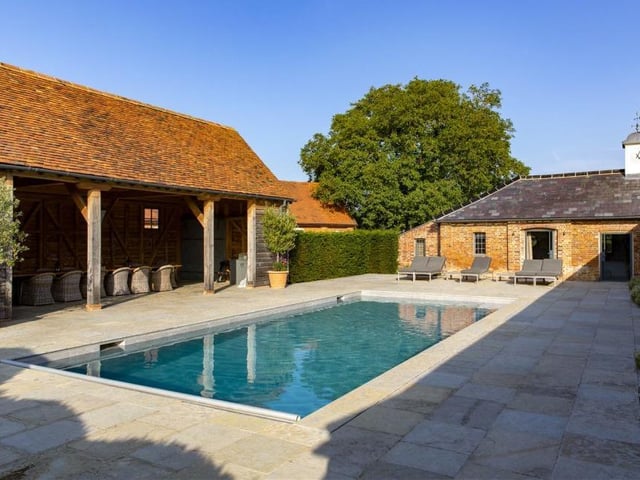 The Hampshire country house is a byword for style and luxury - as you can see from this outdoor swimming pool . It is located in a superb courtyard setting next to a covered dining area or party barn. The pool has a retractable cover too.