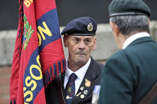 A veteran carries the Royal Engineers Association standard at the parade.