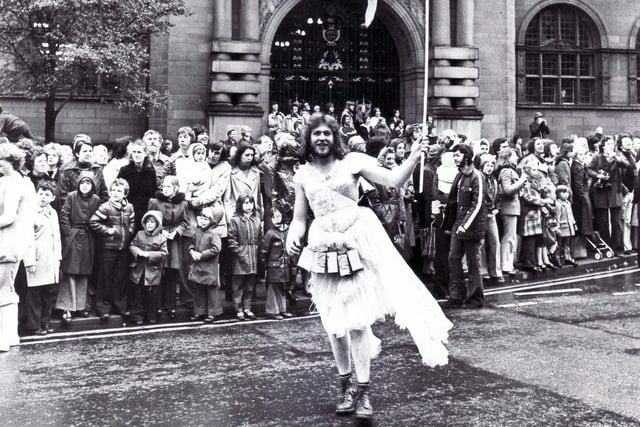 Watched by the crowds, the 1976 Rag Fairy prances in front of the Town Hall, October 23, 1976