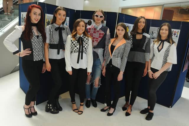 College students take part in a fashion show, displaying upcycled clothing.