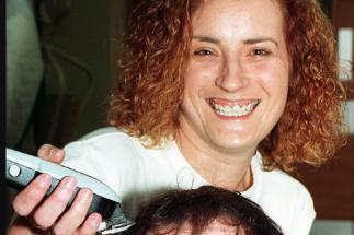 Hairdresser Debbie Hudson getting ready to shave a man's head in 1997.