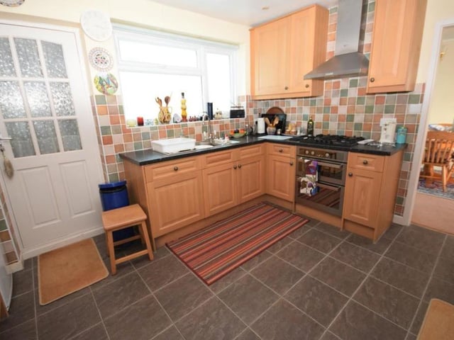 Here is another view of the kitchen, which has a traditional farmhouse feel to it. It is finished with splashback tiles, while the flooring is tiled and there is a uPVC window to the back of the property.