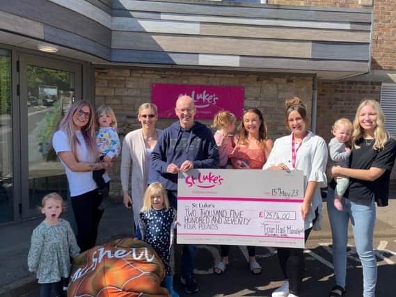 Michael, his family and friends present their latest cheque to Anna Kirk of St Luke's