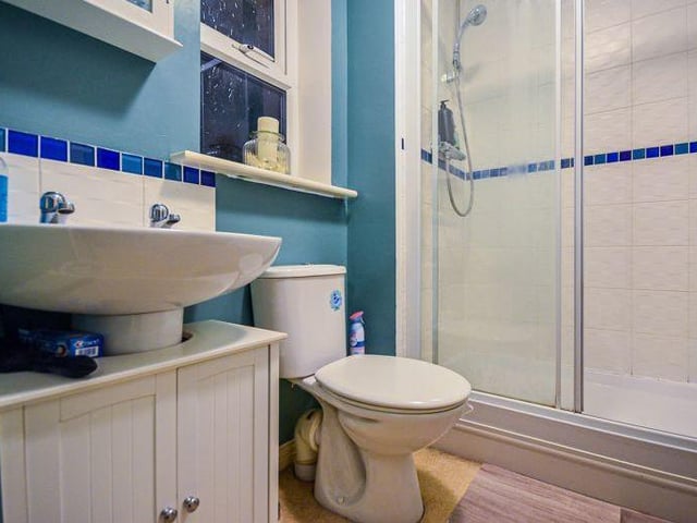 Here is the en suite to the master bedroom. It features a step-in shower cubicle, low-flush WC and wash hand basin with vanity unit.