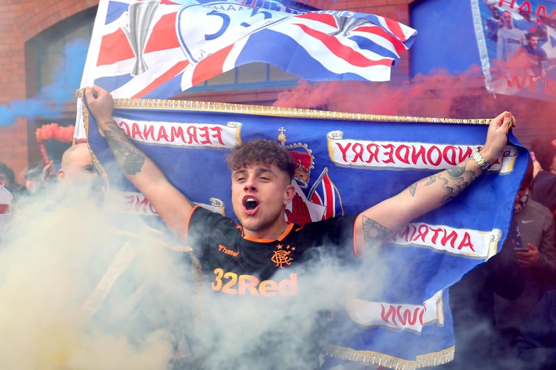 A Rangers fan celebrates outside of the Ibrox Stadium after Rangers win the Scottish Premiership title.