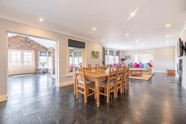 The open plan living kitchen and dining space spans the full width of the rear of the house, with the kitchen flowing into a dining space and sitting area