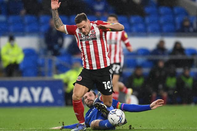 Cardiff, Wales, 4th December 2021. Billy Sharp of Sheffield Utd brought down by Sean Morrison of Cardiff City  during the Sky Bet Championship match at the Cardiff City Stadium, Cardiff. Picture credit should read: Ashley Crowden / Sportimage