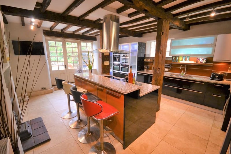 This room also enjoys a feature wood burning stove with stone mantel, exposed brick wall and clay tiled hearth, exposed beam work to the ceiling and complemented with Travertine floor tiles. There is space for a dining table or occasional sofas and access to the utility room.