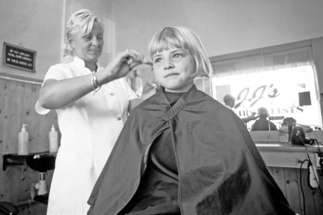 Hairdresser Lisa Carter with a young customer at JJ's Hair Stylists, on Buchanan Road, in Parson Cross, Sheffield, in September 2004.