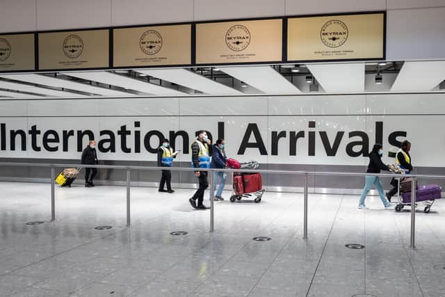 Passengers travelling from one of the countries on the "red list" are escorted through the arrivals area of terminal 5 of Heathrow airport (Photo by Leon Neal/Getty Images)