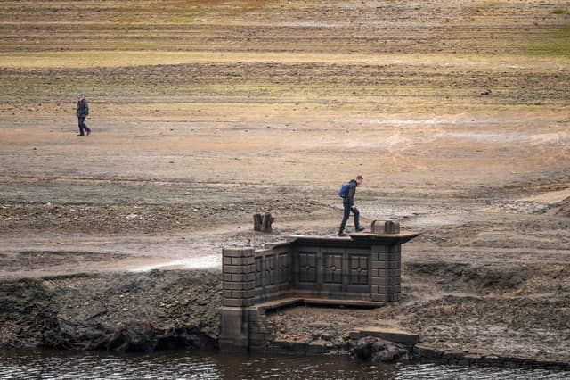People inspect the ruins of Derwent Village, flooded in the 1940s to provide drinking water for the East Midlands and Sheffield, become exposed due to the low water level at Ladybower Reservoir and drought conditions. (Photo by Christopher Furlong/Getty Images)