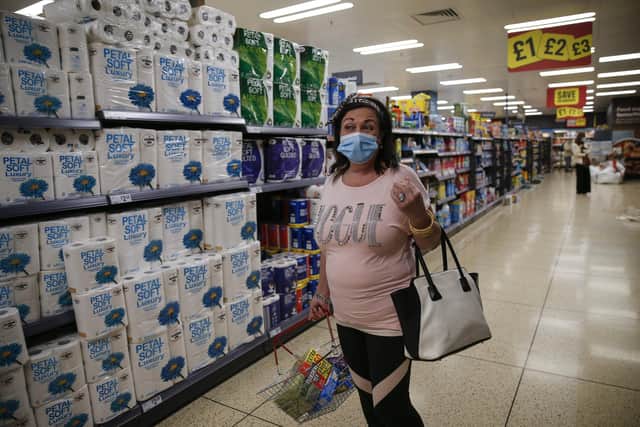 While England's official guidance recommends people wear face coverings in shops and other enclosed spaces, it is not mandatory. (Photo by Hollie Adams/Getty Images)