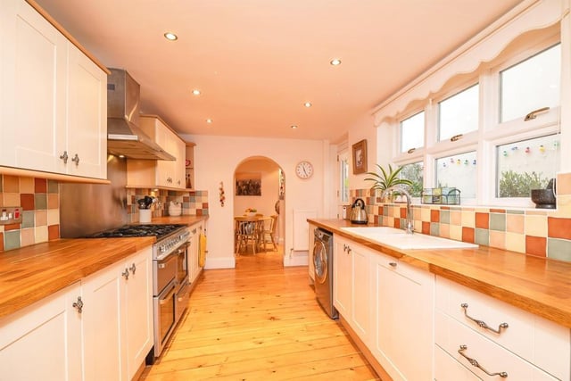 The kitchen has a range of appliances and an archway leading to the breakfast room.