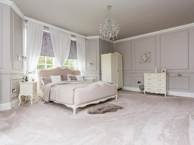 This luxurious large bedroom has great natural light.