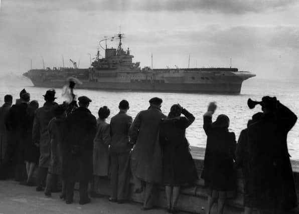 Friends and families wave as HMS Formidable returns to Portsmouth following her tour in the Far East in August 1946.