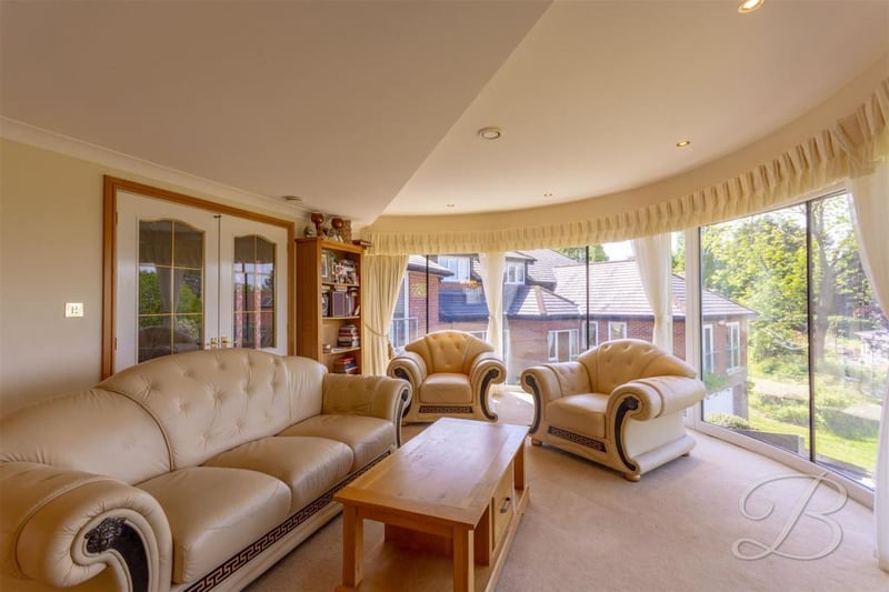 Another view of the warm and homely living room with its curved windows. Ideal for relaxing after a meal.