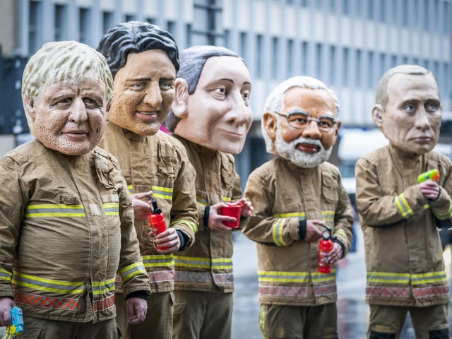 Campaigners wearing 'big heads' of world leaders, including Boris Johnson, Justin Trudeau and Narendra Modi gather for Oxfam's 'Ineffective Fire-Fighting World Leaders' protest performance during the official final day of the Cop26 summit in Glasgow. Picture date: Friday November 12, 2021.