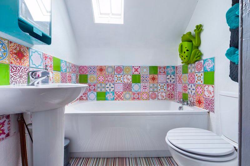 This quirky bathroom has been beautifully finished with unique tiles, vinyl flooring and it's very own frog on the wall!