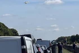 A woman is in hospital with life threatening injuries after a police incident shut the M18 motorway this morning. The picture shows traffic stationary on the carriageway, as the Yorkshire Air Ambulance takes off.