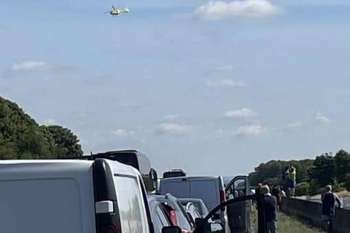 A woman is in hospital with life threatening injuries after a police incident shut the M18 motorway this morning. The picture shows traffic stationary on the carriageway, as the Yorkshire Air Ambulance takes off.