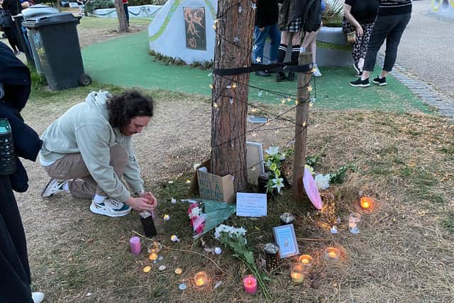 A man lighting a candle in memory of Sabina Nessa