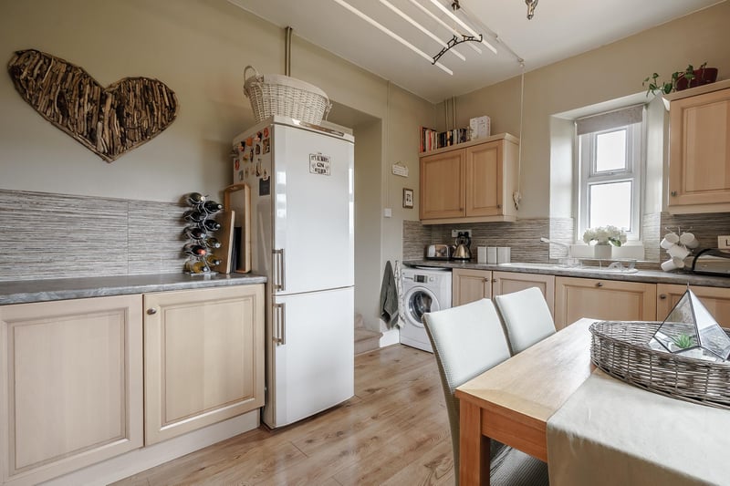 A spacious rear aspect kitchen/dining room with a range of wall and base units, modern integrated appliances and space for a good-sized dining table.