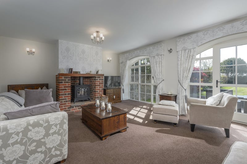 The lounge is a charming and traditional reception space, with brick style inglenook fireplace and arch style windows overlooking the rear garden.