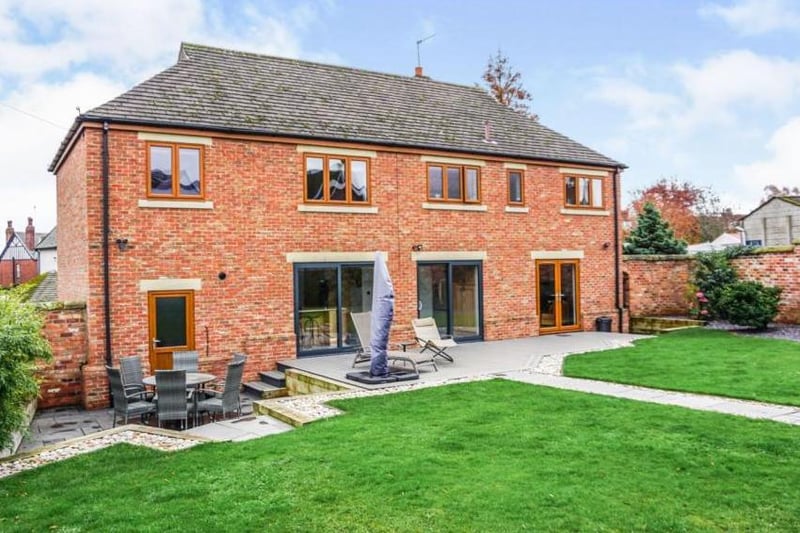 The rear garden, is beautifully landscaped, with lawned and paved patio areas.