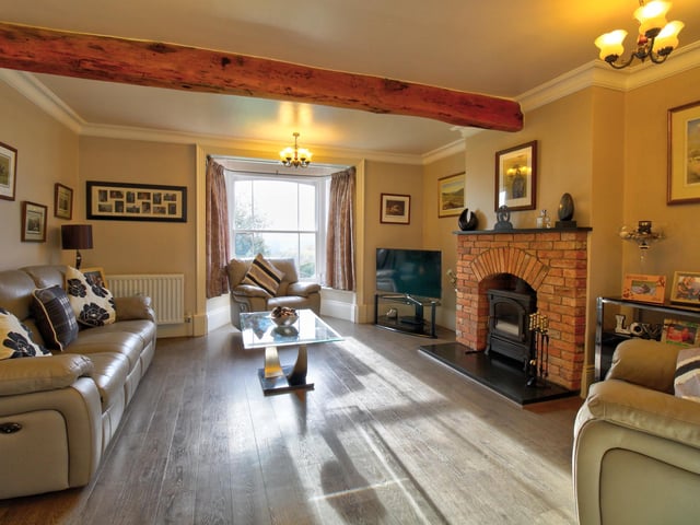 Having feature brick built fireplace with cast iron multi-fuel burner, original beams to the ceiling and bay with sash window.