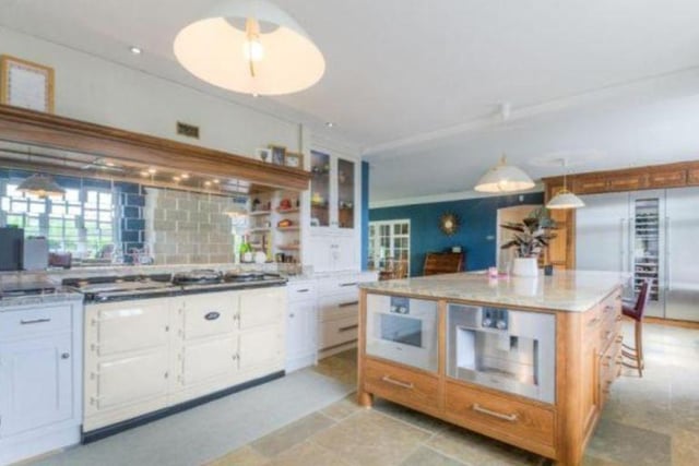 The kitchen is a spacious open plan kitchen-diner with French doors leading to the garden for easy al fresco dining in the summer months. It is fitted with a range of Gaggenau appliances such as two dishwashers, a wine cooler, and a full size Aga.