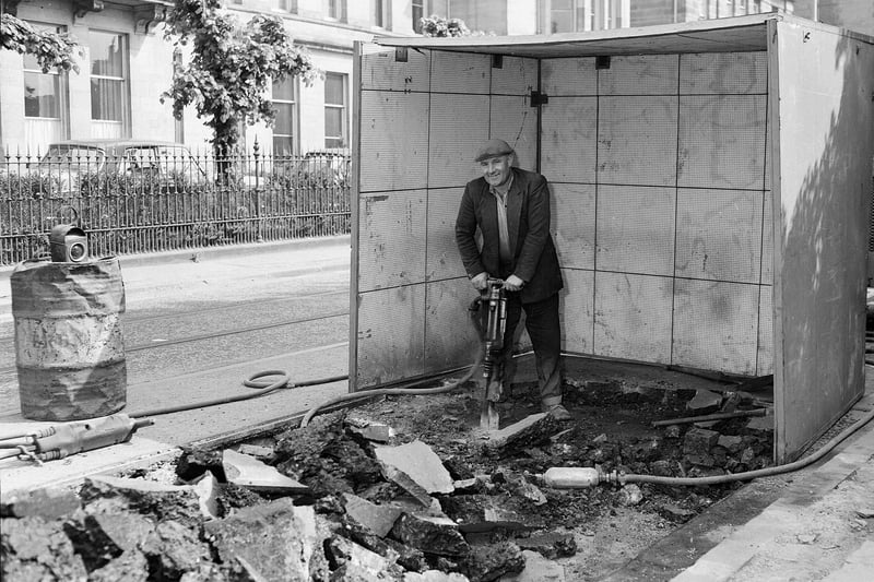 Tram lines are removed from Salisbury Place in May 1961 - Driller Hugh Burns works in a muffle box to drown out the noise for patients in nearby Longmore Hospital.