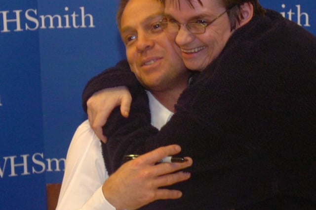 Jason Donovan pictured at his book signing at WH Smith, Meadowhall. One fan gives him a hug