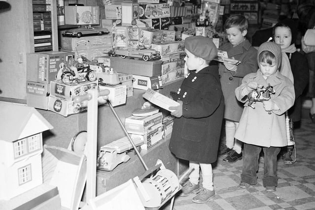 Children inspect some prospective Christmas presents in the Thornton's toy department in 1958.