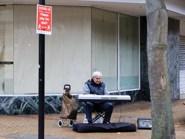 A musician in the town centre as the town enters tier 3
