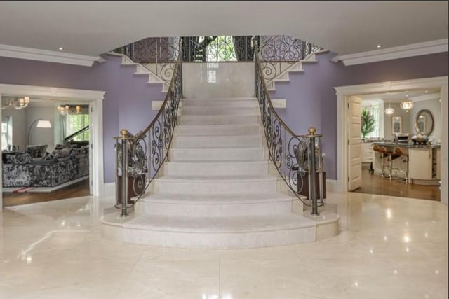 The grand entrance hall which features impressive marble flooring and leads to the principal downstairs accommodation, while the central curved marble staircase leads to the upper floor. Image by Rightmove.