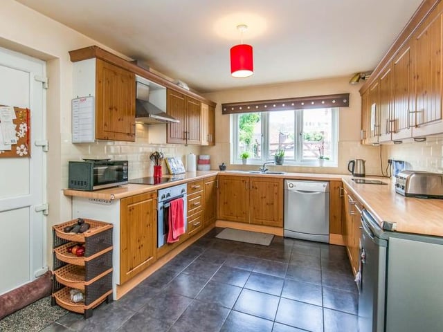 The main kitchen area is of a good size and boasts all the amenities you need, including a range of wood-effect wall and base units, integrated electric oven, stainless-steel sink and ceramic tiled floor.