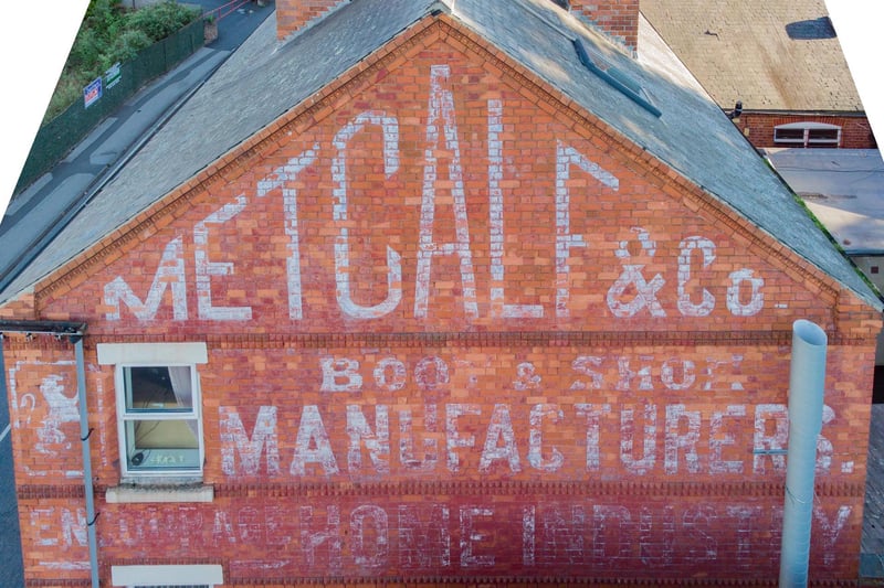 Sign on the old Metcalf & Co shoemakers on the end wall of The Market chip shop on South Street