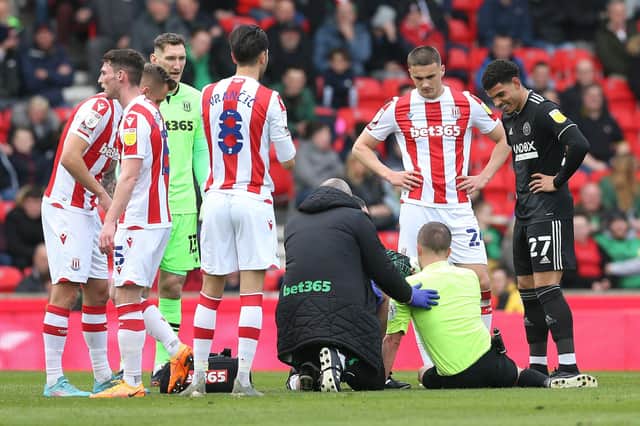Referee David Webb lies injured after being struck by the ball during the Stoke v Sheffield United game: Barrington Coombs/PA Wire.