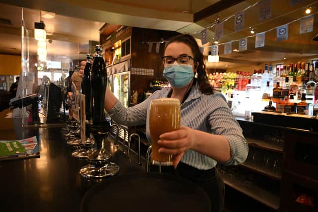 A member of the bar staff pulls a pint in a Wetherspoons pub (Photo by Oli SCARFF / AFP) (Photo by OLI SCARFF/AFP via Getty Images)