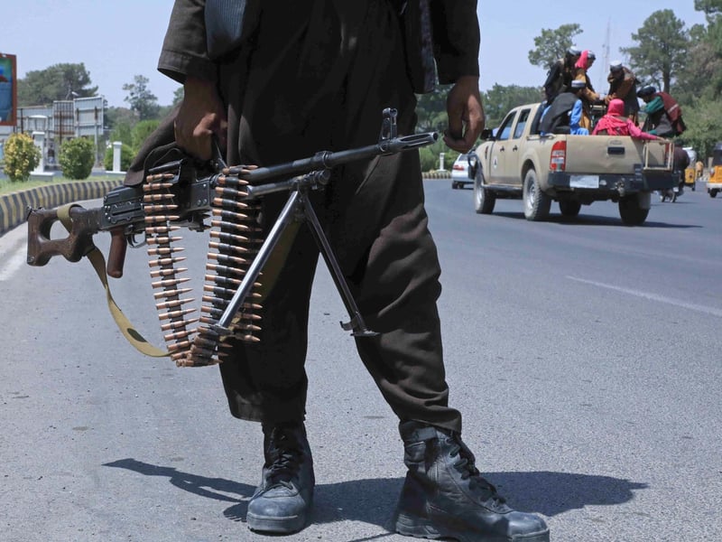 A Taliban fighter stands guard on a street in Herat